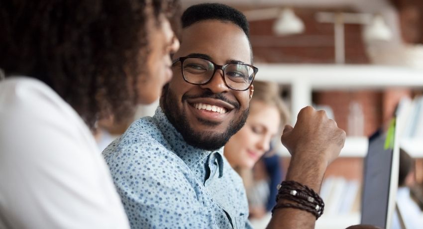 colaborador feliz conversando com a colega de trabalho 
