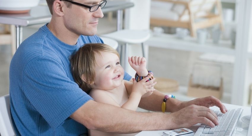 funcionário com seu filho pequeno trabalhando em home office